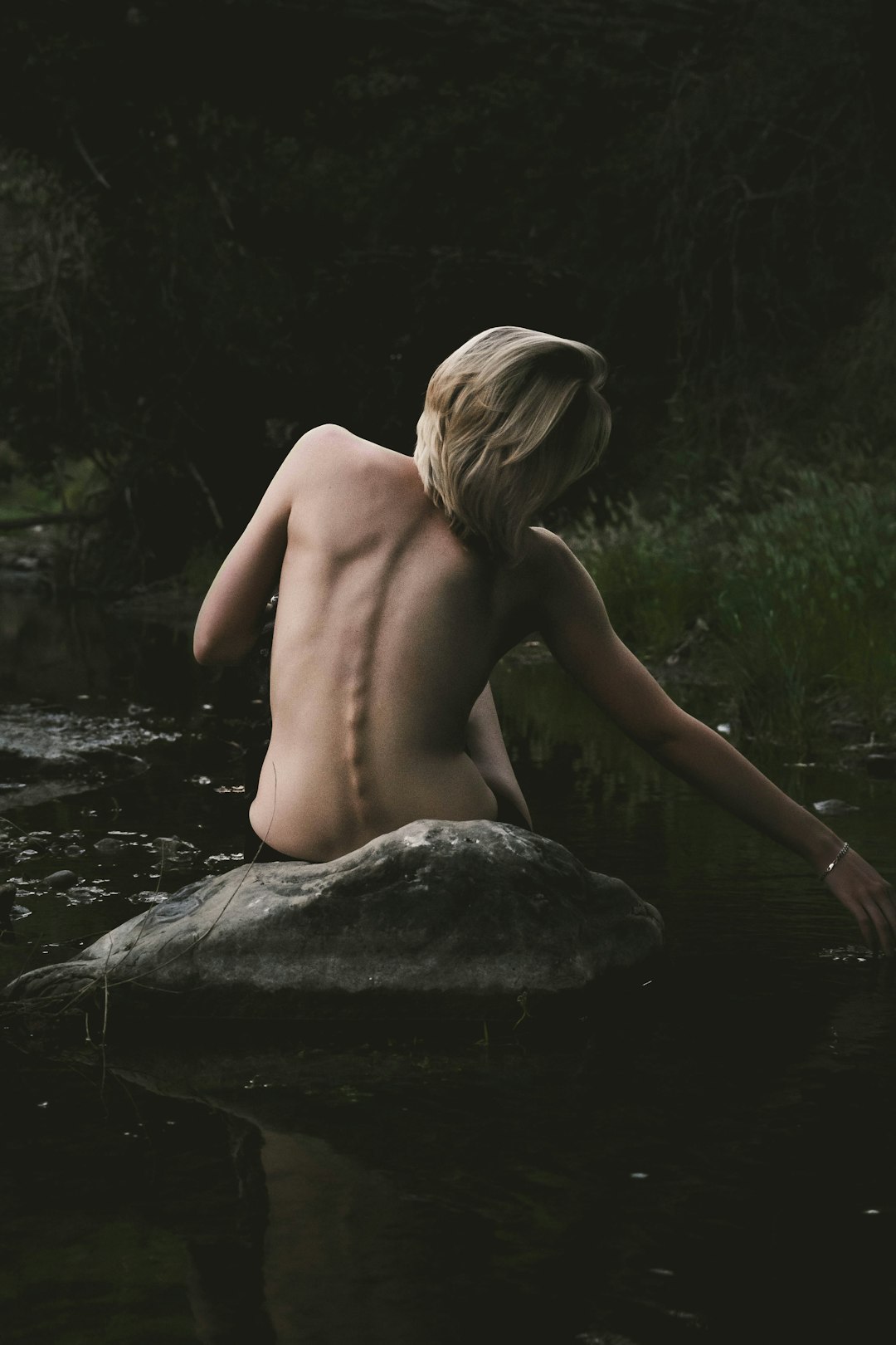 Photo by Casper Nichols half naked woman sitting on rock